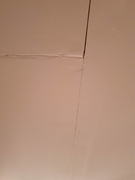 Ommålat tak med synliga gipsskivskarvar och spikhål som behöver spackling och reparation.