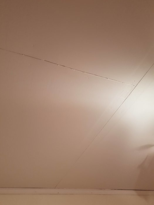 Ommålat tak med synliga skarvar mellan gipsskivor och ojämnheter.