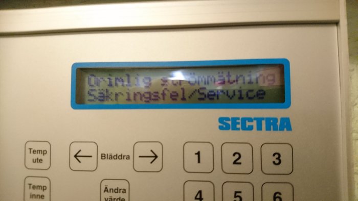 Elvärmesystem med display som visar felmeddelande "Säkringsfel/Service", omgivet av styrknappar.