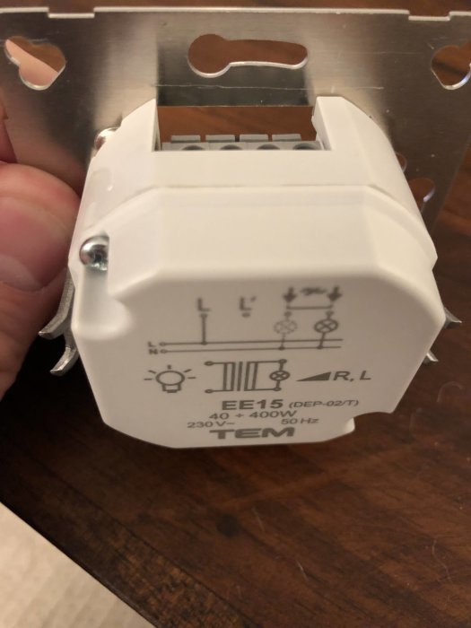 Närbild på en elektrisk dimmer med tekniska specifikationer och kopplingsschema.