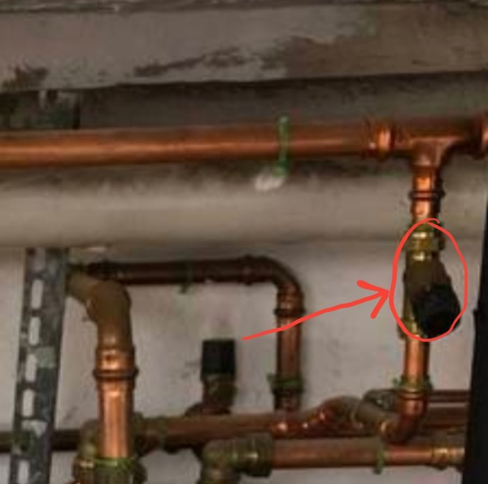 Rörsystem med kopparledningar och en markering som pekar på en potentiell läcka.