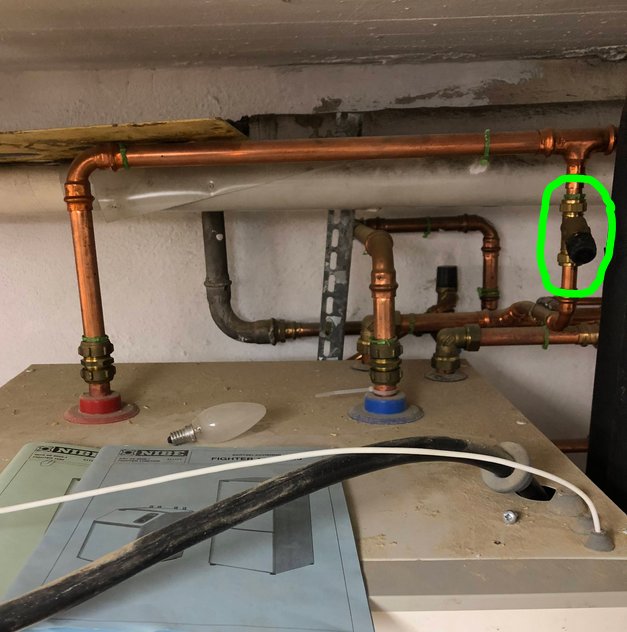 Vattenrör och ventiler under tak, påfyllningsventil markerad med grön cirkel.