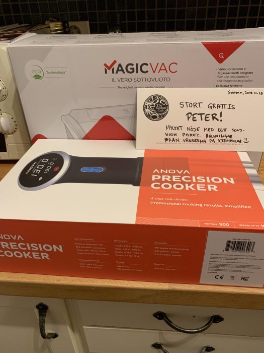 Köksbänk med ett nytt sous-vide paket från MagicVac och Anova Precision Cooker, med en gratulationslapp.