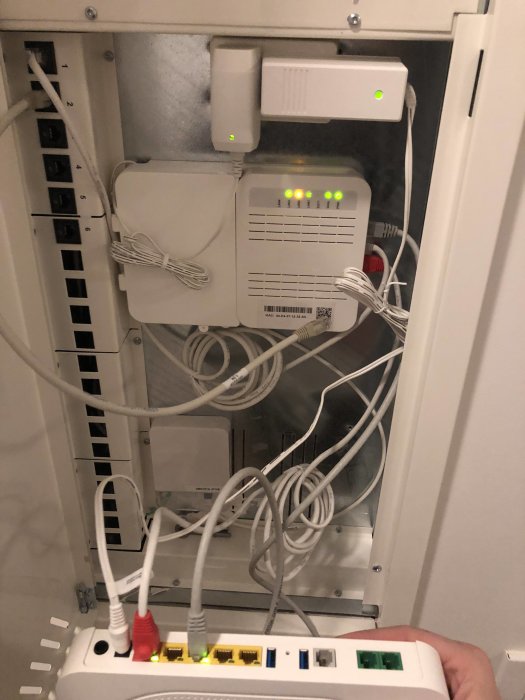 Mediaskåp med router, switch och nätverkskablar i en ny lägenhet.