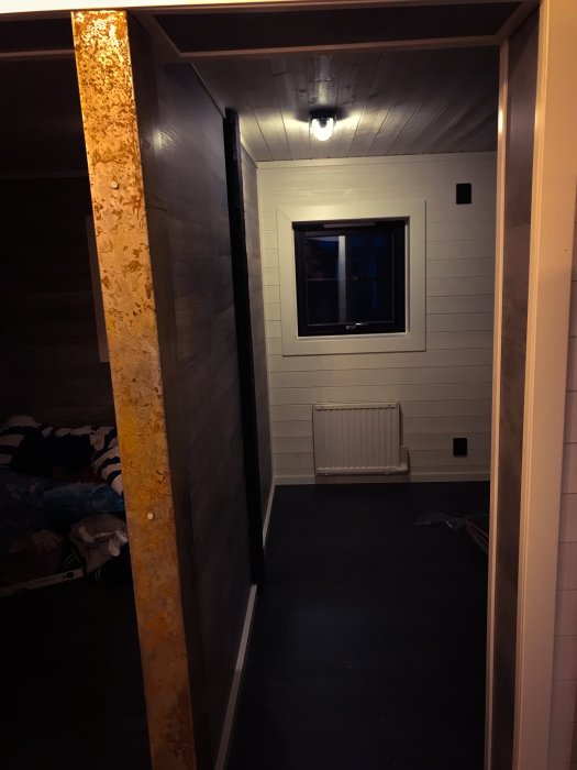 Färdigställt gästrum med vit panel och mörkt golv redo för inredning.