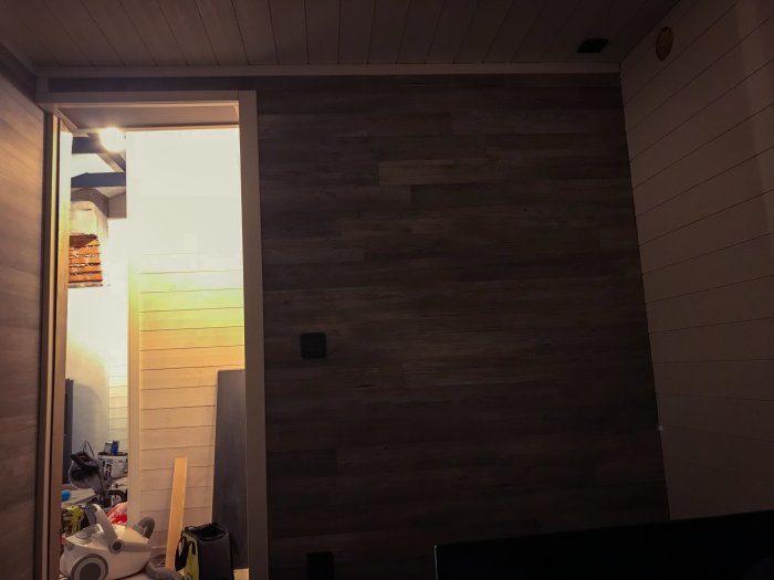 Nyrenoverat sovrum med mörkt trägolv och vägg, redo för kontinentalsäng.
