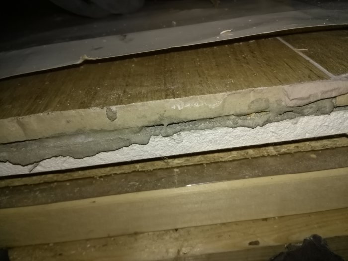 Ojämn öppning mellan två golv med synlig höjdskillnad och råa kanter som behöver täckas.
