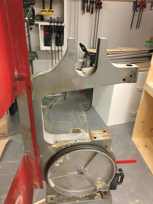 Nedmonterad såg i verkstad med synlig rost och verktyg i bakgrunden.