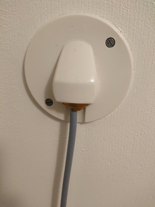 Väggmonterad 230V perilexkontakt för tvättmaskin med ansluten kabel.