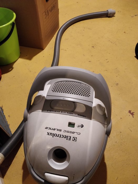Dammsugare av märket Electrolux på ett gult golv vid återvinningscentral.