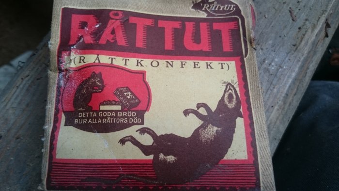 Sliten vintageförpackning av RÅTTGIFT med teckningar av råttor och texten "DET GODA BRÖD BLIR ALLA RÅTTORS DÖD".