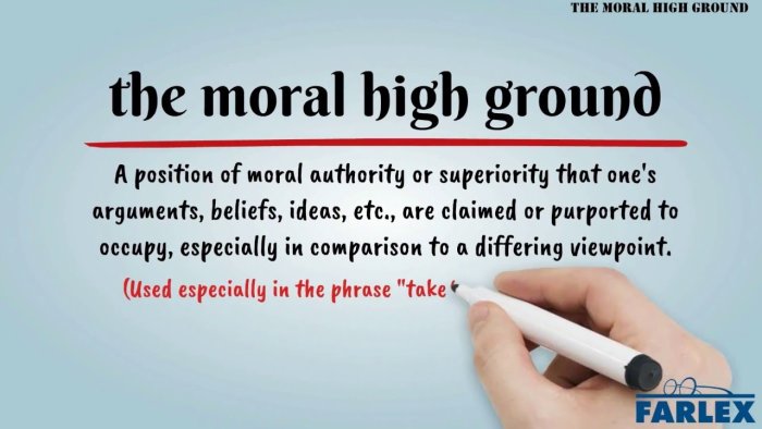 Definition av uttrycket 'the moral high ground' skrivs på vit yta med blå bakgrund och en hand håller en tuschpenna.