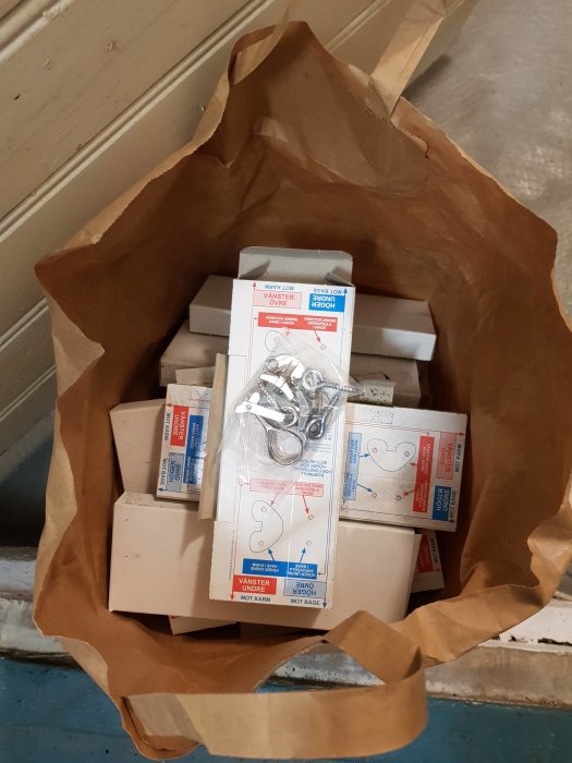 Brun papperskasse med flera askar fönsterhakar, något öppna, utan tätlist.