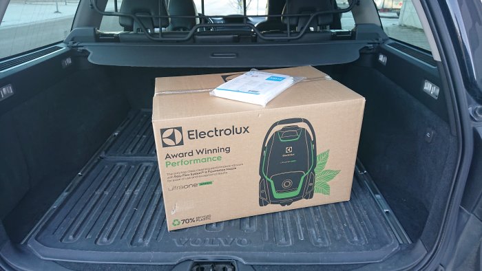 En ny Electrolux dammsugare fortfarande i kartongen placerad i bagageutrymmet på en Volvo.