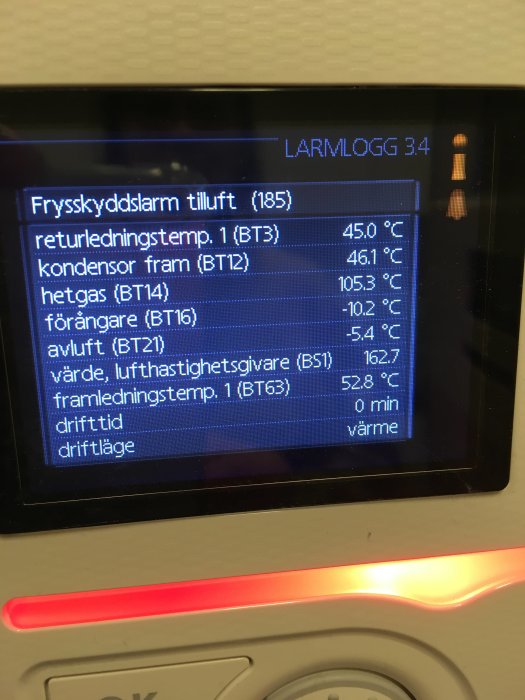 Display på en värmepumps larmlogg med temperaturvärden och ett aktiverat frysskyddslarm.