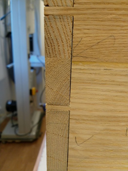 Trädetalj med urfräst spår och angränsande laxstjärtssammanfogning i närbild.