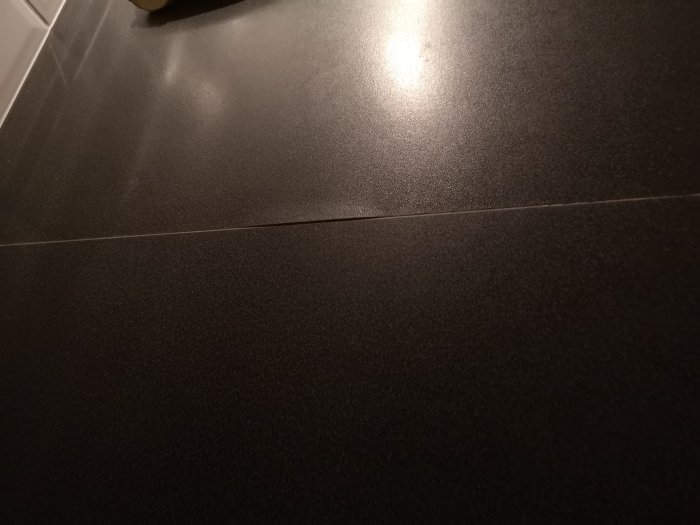 Svullen bänkskiva med synlig skada och misstänkt fuktpåverkan.
