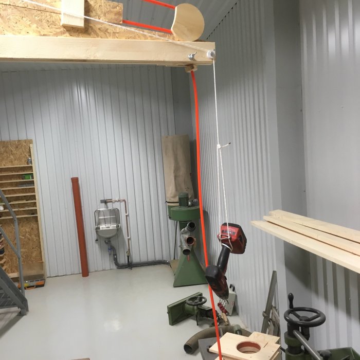 Snickeriverkstad med en improviserad balansanordning med snöre och motvikt av tvingar.