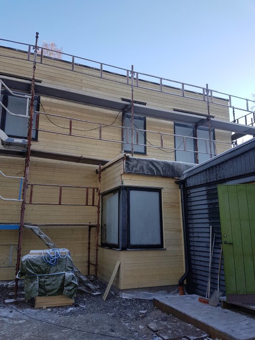 Hus under renovering med ny monterad panel och ställningar runtomkring.