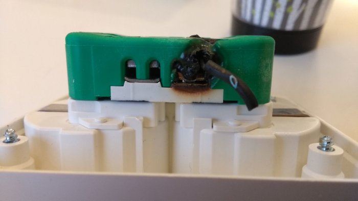 Eluttag med bränd anslutning där ledaren inte är korrekt installerad.