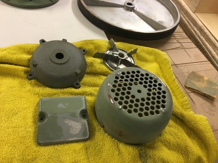Demonterade bromskomponenter torkar på handduk, väntar på rengöring och målning.