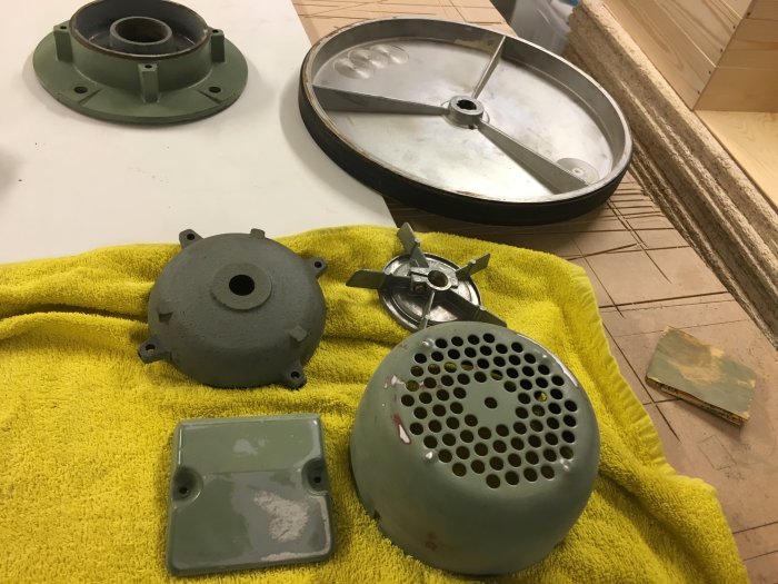 Delar av bromssystem, inklusive en fjäder, demonterade och rengjorda, ligger på en gul handduk för underhåll.