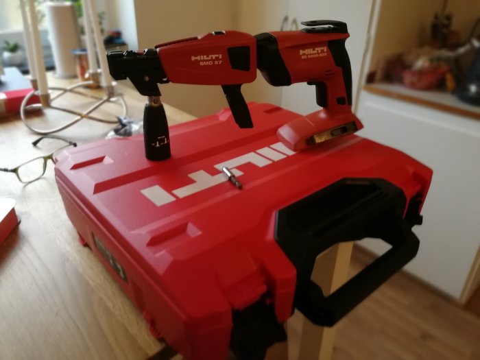 En ny Hilti skruvautomat ovanpå en röd Hilti verktygslåda i ett hemunder renovering.