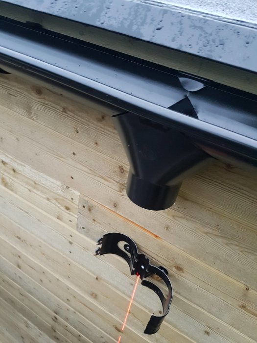 Nytt stuprör på trävägg med kryssförlagd laserstråle för positionering.