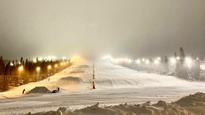 Kvällsbelysning på Lindvallens skidbacke med preparerade pister och snö.