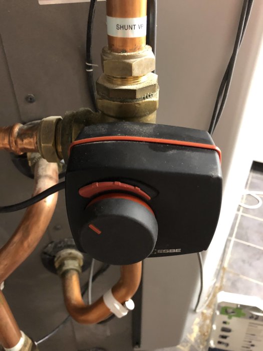 Närbild på en shuntmotor monterad på rör med etiketten "SHUNT VF" i en VVS-installation.