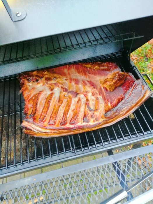 Stor revbensspjäll på grillen med grillränder och köttsaft.