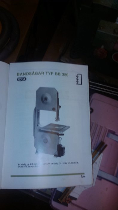 Instruktionshäfte för bandsåg typ BB 350 öppnat på arbetsbord med diffust bakgrund.