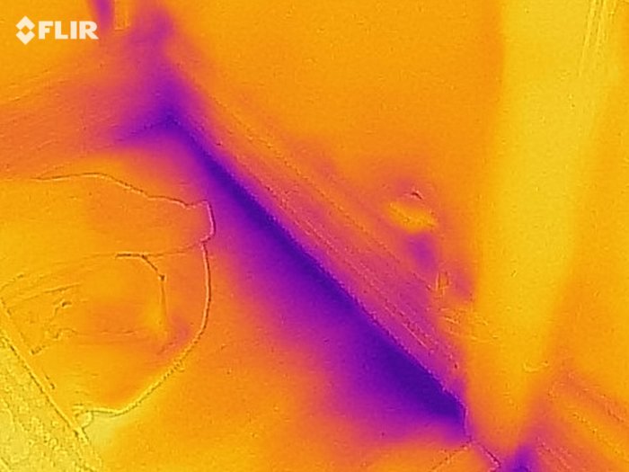 Termisk bild på vägg med värmeläckage indikerat av färgvariationer.