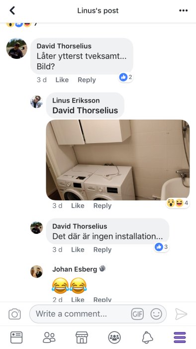 Tvättmaskin och torktumlare staplade asymmetriskt i ett hörn bredvid en tvättho och väggskåp.