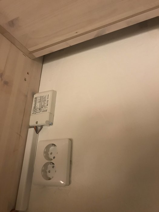 Överskåp i kök med synliga elektriska ledningar och 230V uttag med slarvig installation.