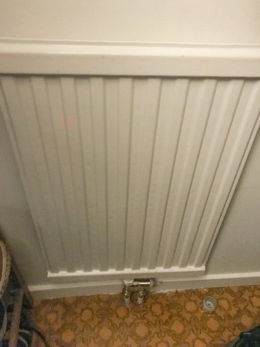 Vit radiator AGA FRV15 med termostatventil, svagt synlig läckage indikerat av användaren.