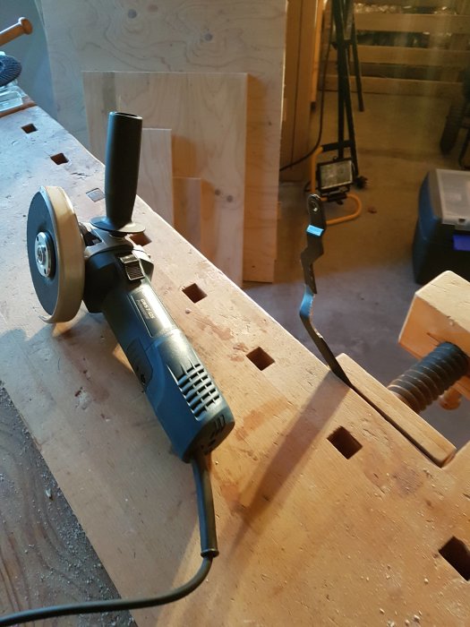Vinkelslip uppsatt för reparation på ett arbetsbänk i en byggmiljö.