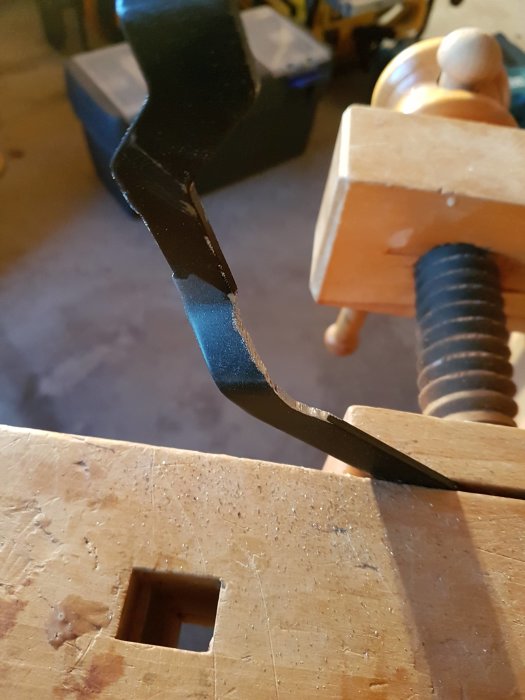 En vinkelslip används för att reparera en kap/ger-såg med slitage, i en verkstadsmiljö.