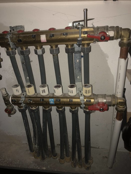 Fördelarblock för golvvärme med inställningsrattar och etiketter, returrör nr 2 från vänster.
