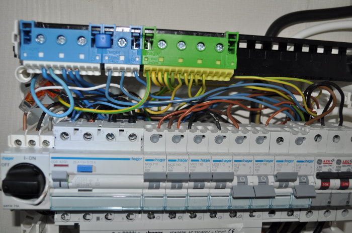 Elektrisk huvudcentral med flera ledningar och säkerhetsbrytare, varav tre går ut från undercentralen.