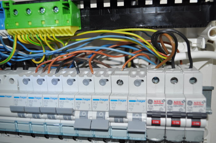 Elektrisk huvudcentral med flera säkringar och färgkodade kablar som ansluter till olika utrustningar.