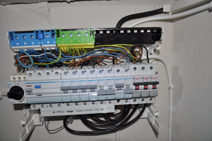 Elektrisk huvudcentral med säkringar och tre utgående kablar ordnade efter installationstidpunkt.