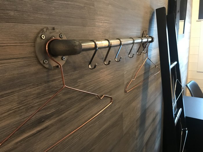 Rostig plåt skjutdörr med rå OSB och läderflärpshandtag samt träklädd vägg använt som inspirerande interiör.