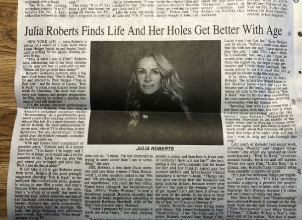 Newspaper page with an article titled "Julia Roberts Finds Life And Her Holes Get Better With Age" with her portrait.