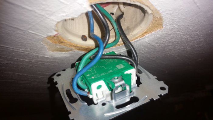 Nyinstallerad elektrisk väggströmbrytare med sladdar korrekt inkopplade i en öppen vägguttag.