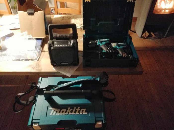 Nya Makita-verktyg utlagda på golv, inklusive en borr i en öppen låda och en bärbar högtalare.