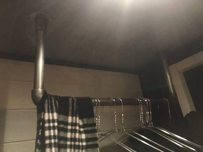Laminattak med betongutseende i ett hem, med handdukar hängande på en metallstång.