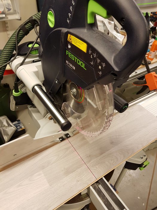 Kap- och gersåg från Festool som används för att längskapa ett ljust golvplank.