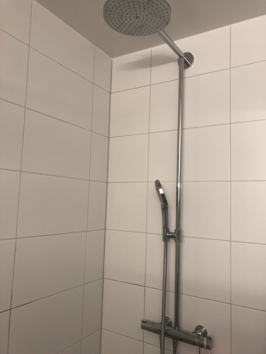 Hansgrohe Raindance 240 dusch med takdusch och handdusch i ett kaklat badrum.