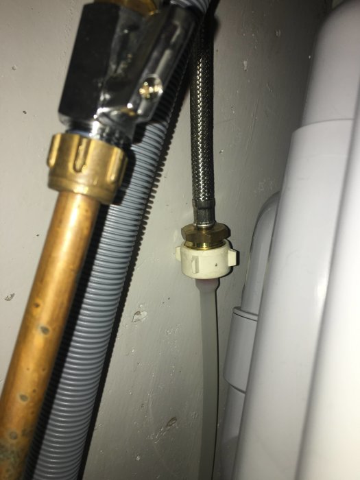 VVS-installation med kopparledning, flexibel slang och ventil ovanför ballofix vid vägg.